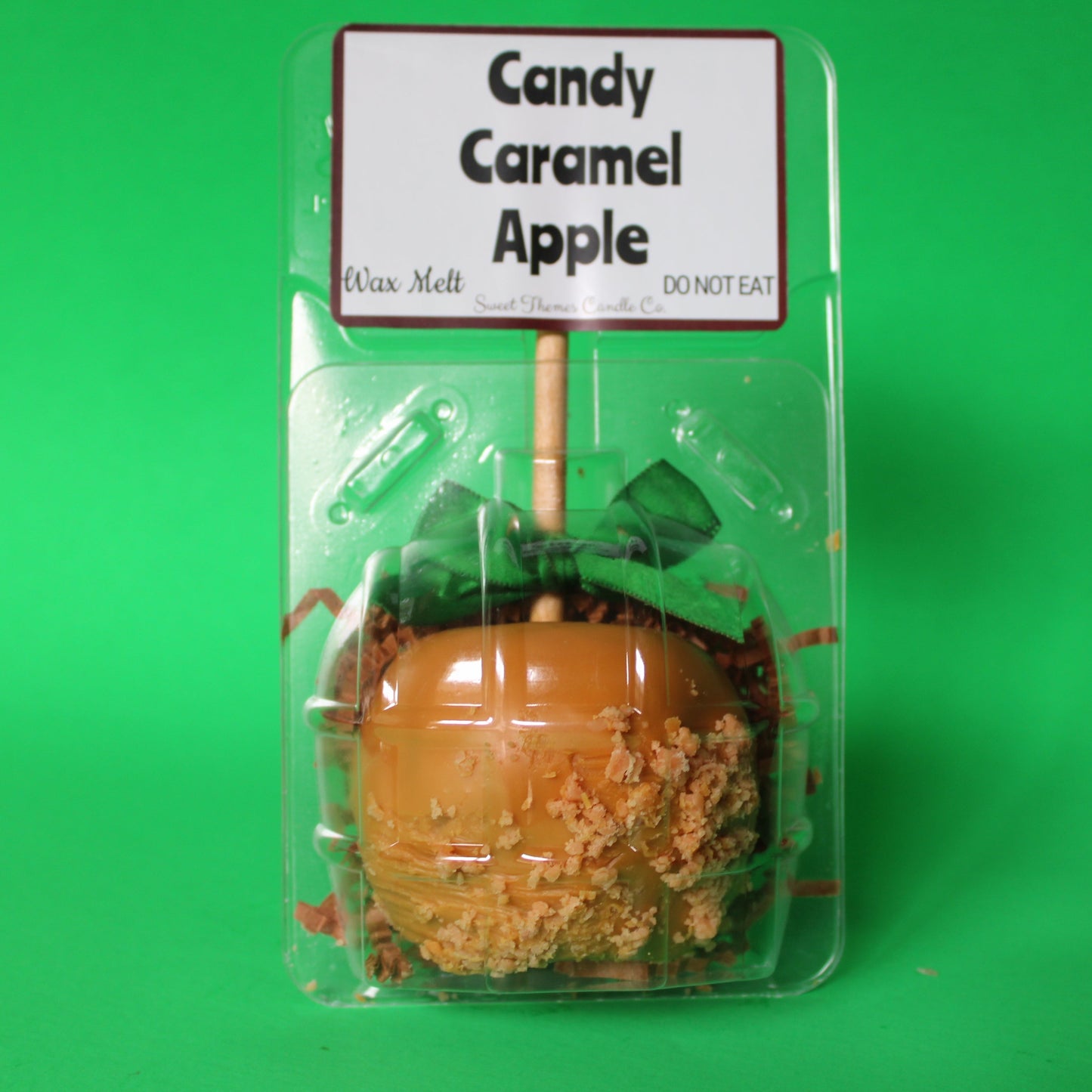 Candy caramel apple in packaging with a label on a green background